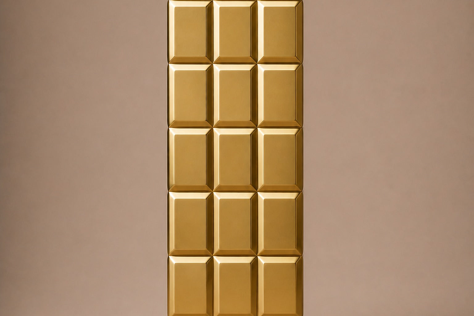 Tall polished brass column built as a grid of raised cushioned panels.