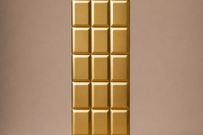 Tall polished brass column built as a grid of raised cushioned panels.
