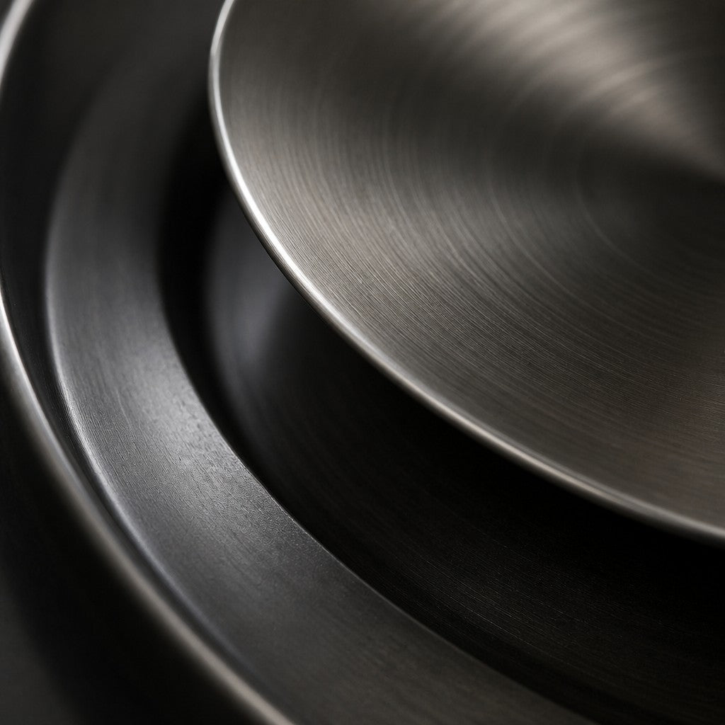 Piatto — 100 × 100 cm round blackened bronze wall dish with a turned steel centre, close studio detail of the surface and material