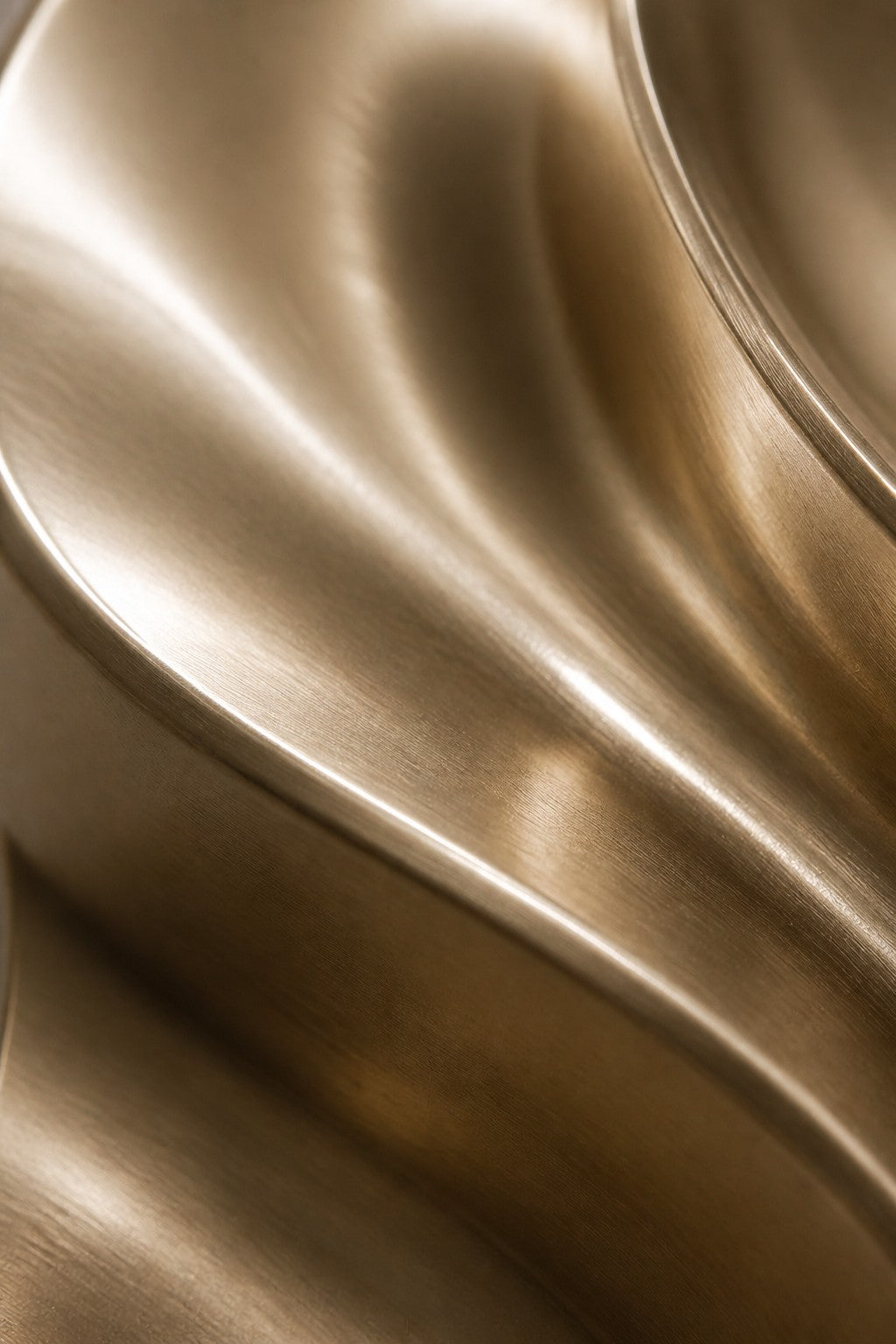 Piega — 90 × 130 cm champagne brass wall relief of a folded oval, close studio detail of the surface and material