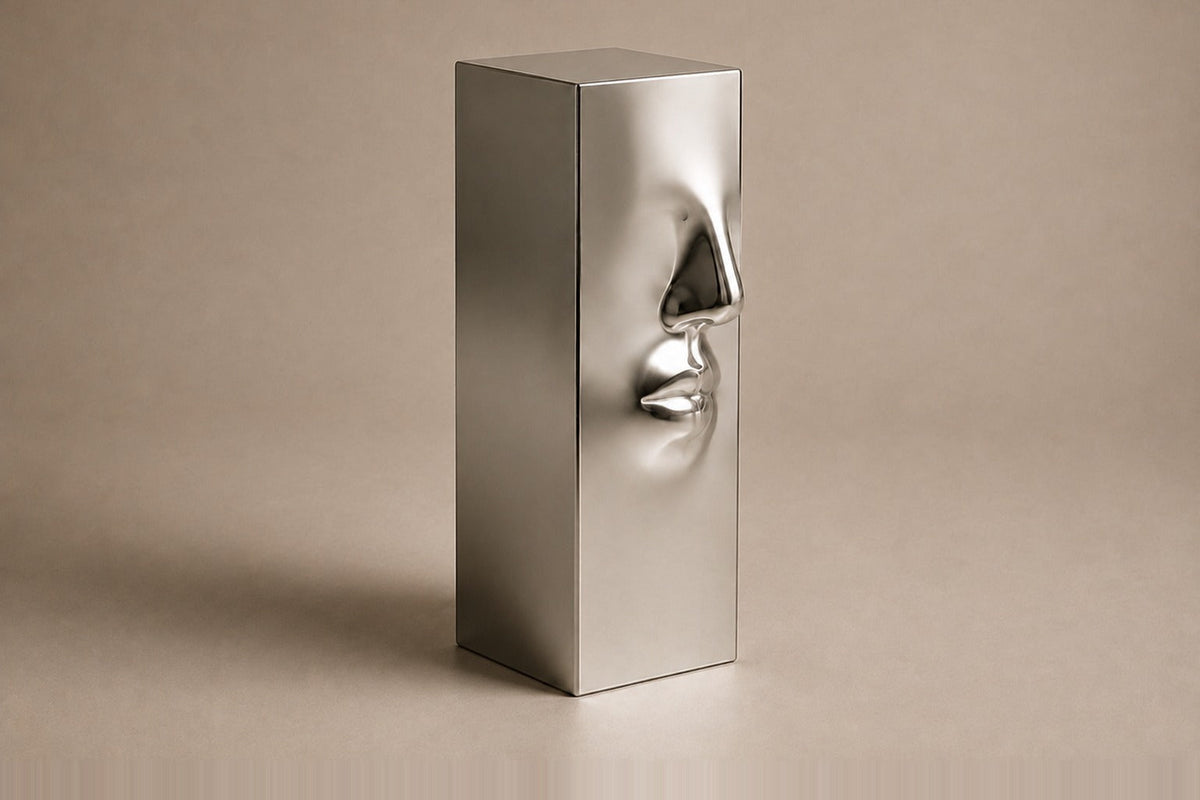 Tall mirror-polished stainless steel pedestal with a nose and mouth formed seamlessly out of one face — three-quarter studio view of the whole pedestal