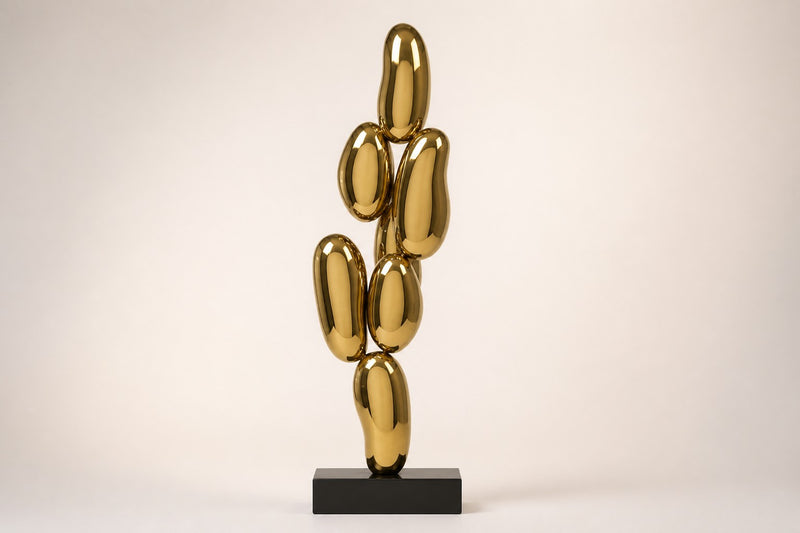 Pukyu — column of seven mirror-gold bubbles on a black base, studio front view