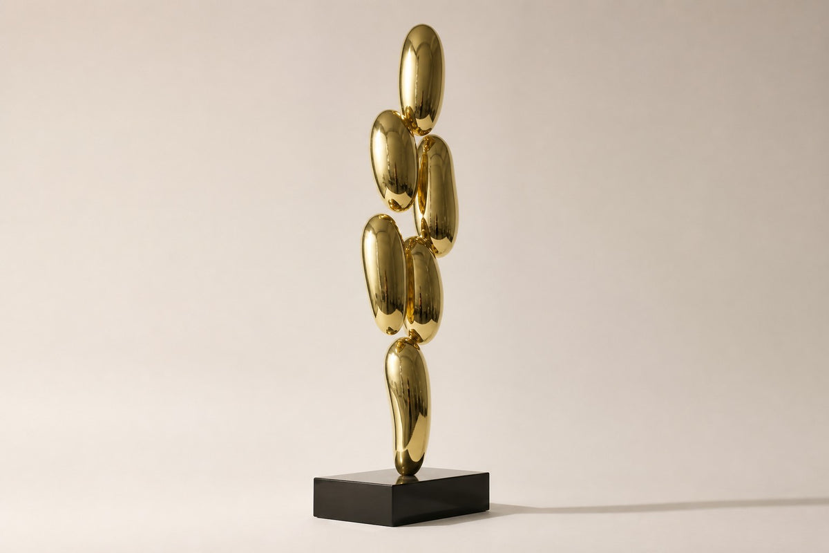Pukyu — column of seven mirror-gold bubbles on a black base, studio side angle showing its depth