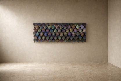 Rust orange and umber bronze wall sculpture Corteza, cast bark-textured plates shingled across a long rail, on a plaster wall.