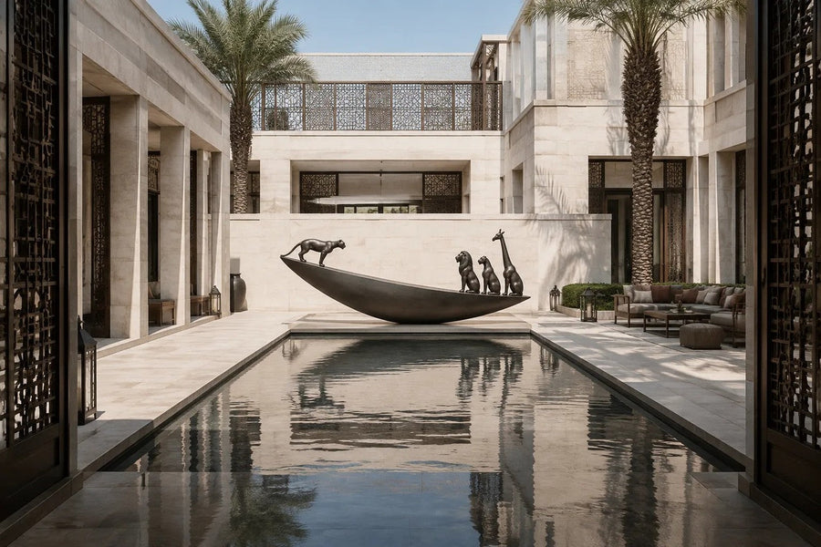 Dark bronze crescent sculpture Quebrada balanced on its curve, three seated forms at the high end and one walking down the fall.