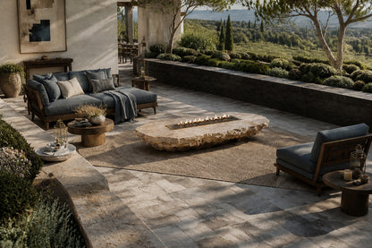 Coral travertine fire table Rimala 220, warm coral and honey, on a pale stone floor.