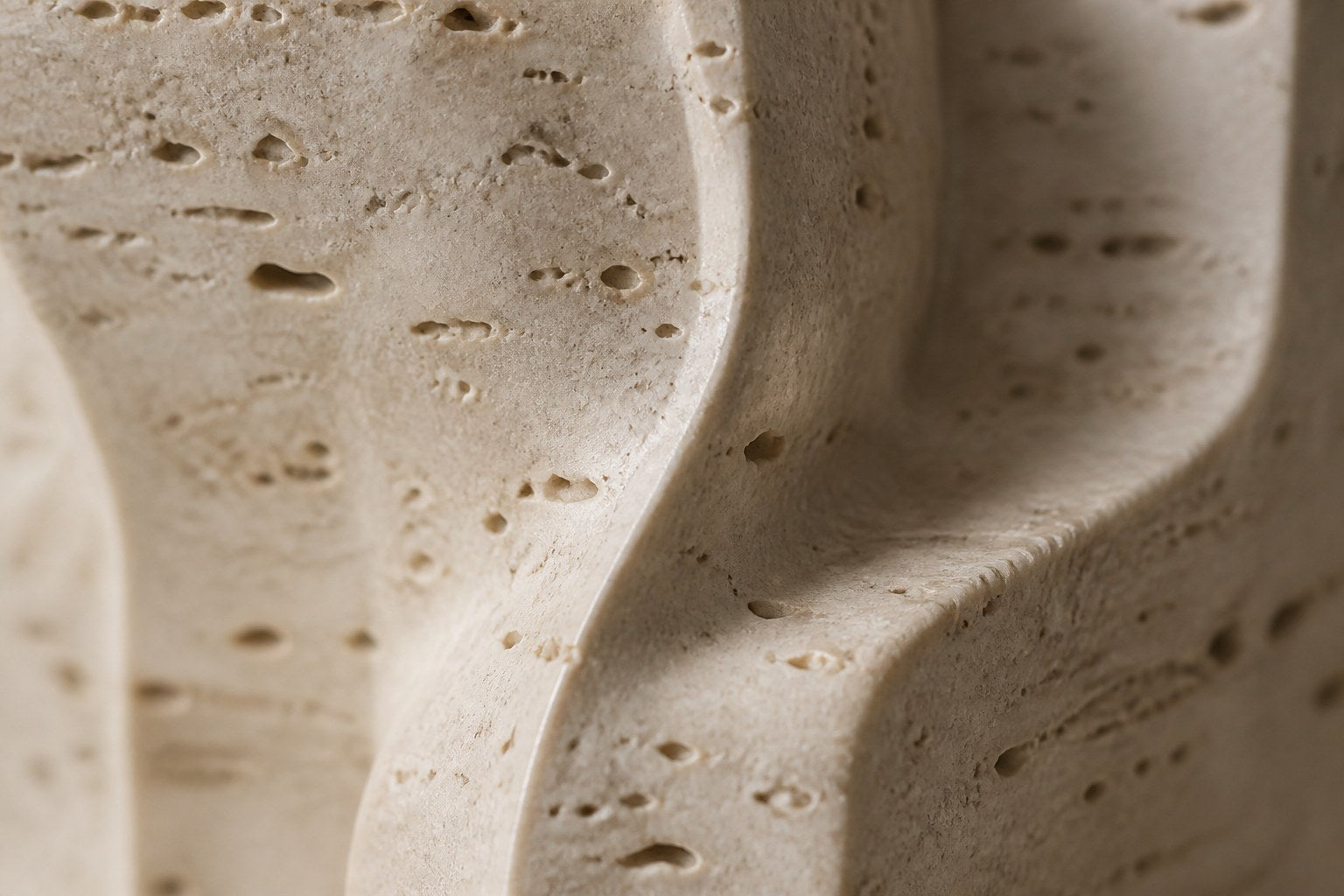 Cream travertine sculpture Ruchbah, a column of stacked interlocking carved blocks on a travertine drum plinth.