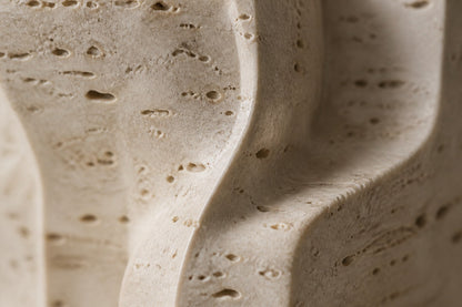Cream travertine sculpture Ruchbah, a column of stacked interlocking carved blocks on a travertine drum plinth.