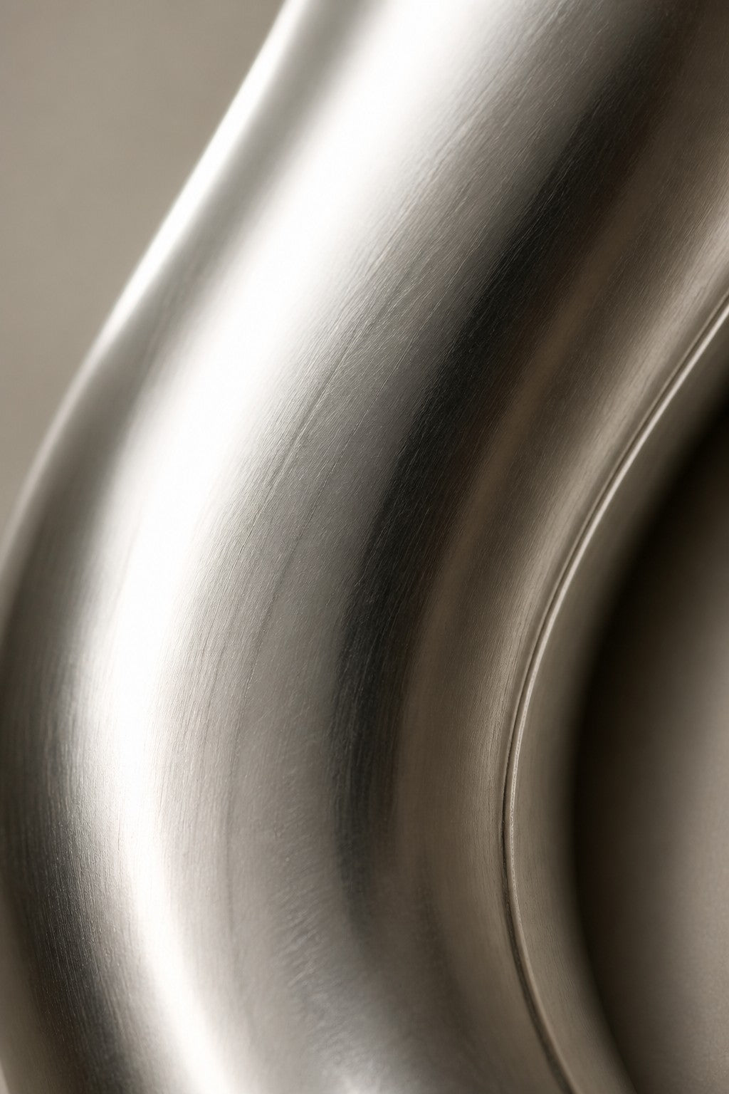 Dark bronze bronze wall sculpture Lingote, stacked cast billets offset on a concealed spine, on a plaster wall.