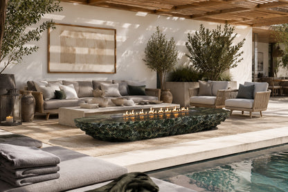 Deep green marble fire table Sacharu 220, deep green with pale veining, on a pale stone floor.