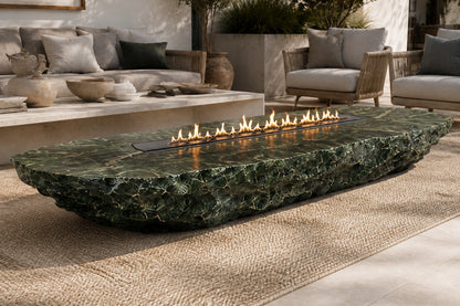 Deep green marble fire table Sacharu 220, deep green with pale veining, on a pale stone floor.