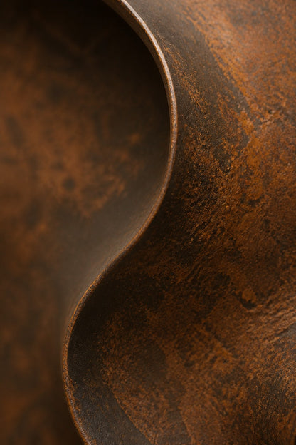 Satin steel steel wall sculpture Eco, concentric rings stepping back to a recessed centre, on a plaster wall.