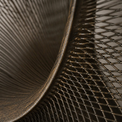 Smoke grey bronze wall sculpture Nebulosa, fine wire woven across a circular rim around a drifting void, on a plaster wall.