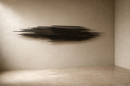 Graphite steel wall sculpture Saeta, a single tapered blade laid across a concealed rail, on a plaster wall.