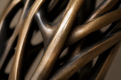 Bronze strut-cage sculpture Sbalzo forming an inverted arch, gilt and blackened, on a beaded travertine block.