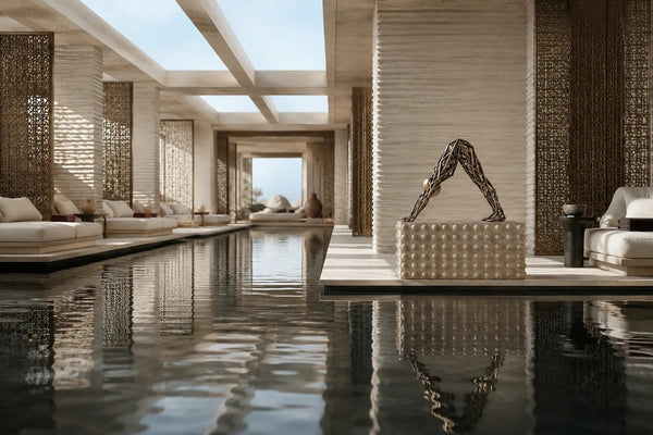 Sbalzo, a bronze figurative sculpture beside an indoor pool in daylight