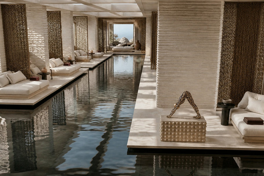 Bronze strut-cage sculpture Sbalzo forming an inverted arch, gilt and blackened, on a beaded travertine block.