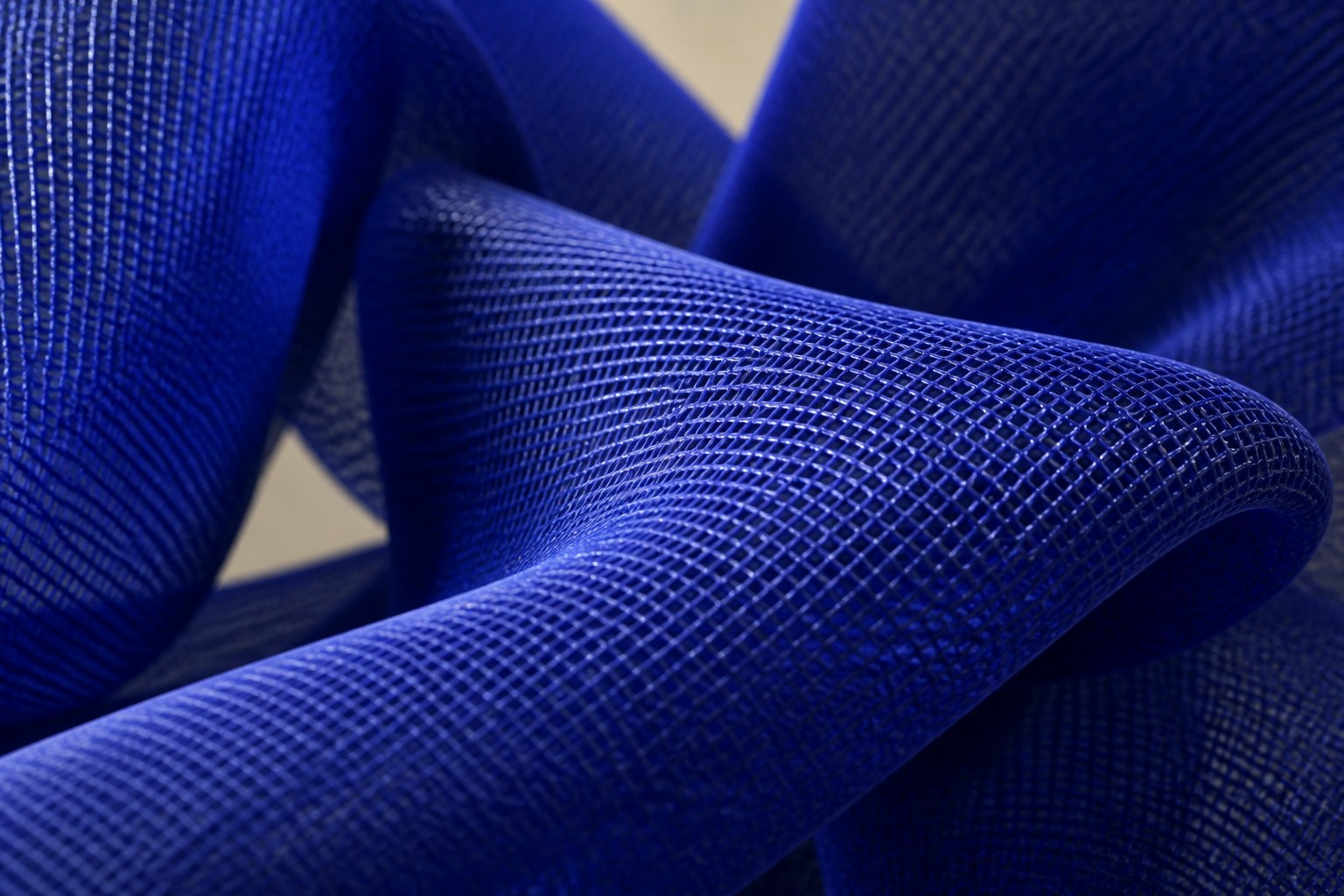 Cobalt blue woven wire sculpture Shaula, a draped form with two raised lobes and a long sweep trailing to the floor.