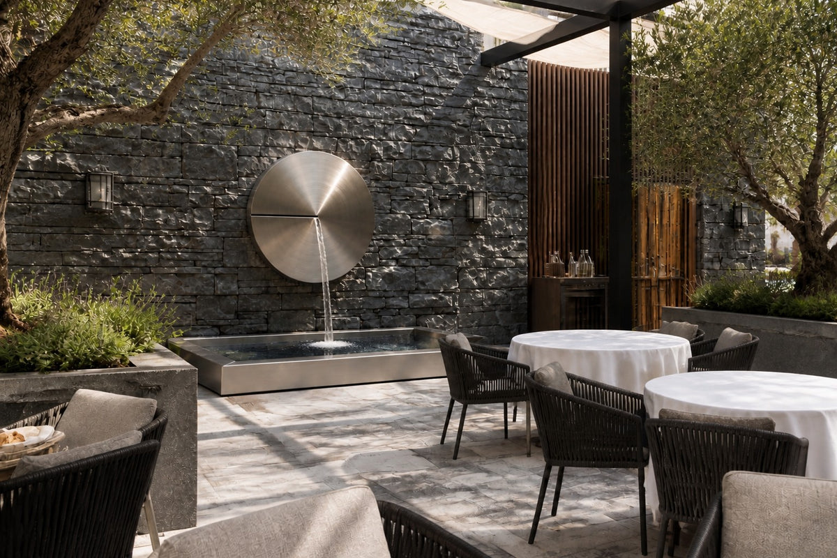 Solace — Ø 100 cm brushed stainless disc wall fountain, close view on the wall with water running