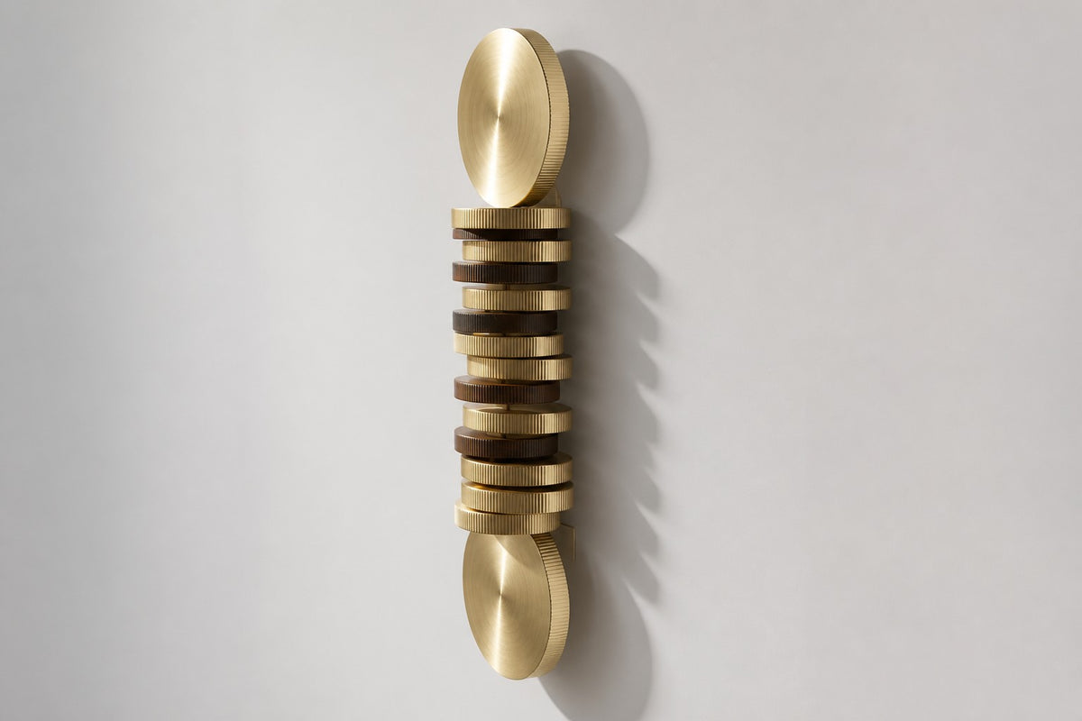 Solana — vertical brass and bronze disc column wall sculpture, studio side angle showing its depth