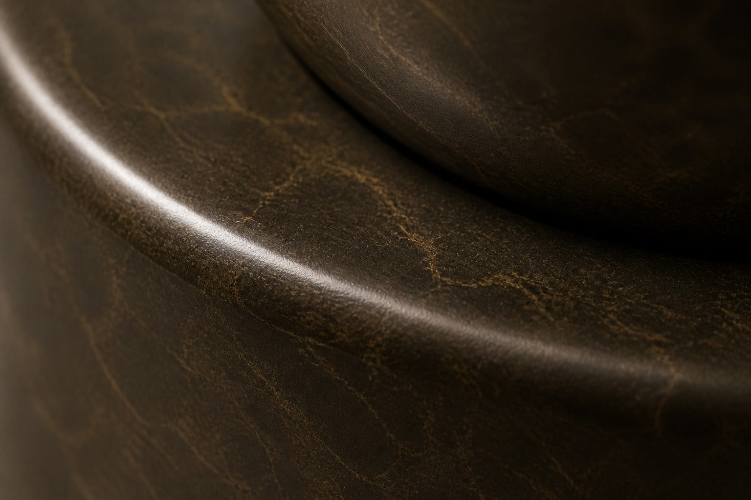Dark marble pedestal fountain Sombra Ø65, dark olive-bronze, on a pale stone floor.