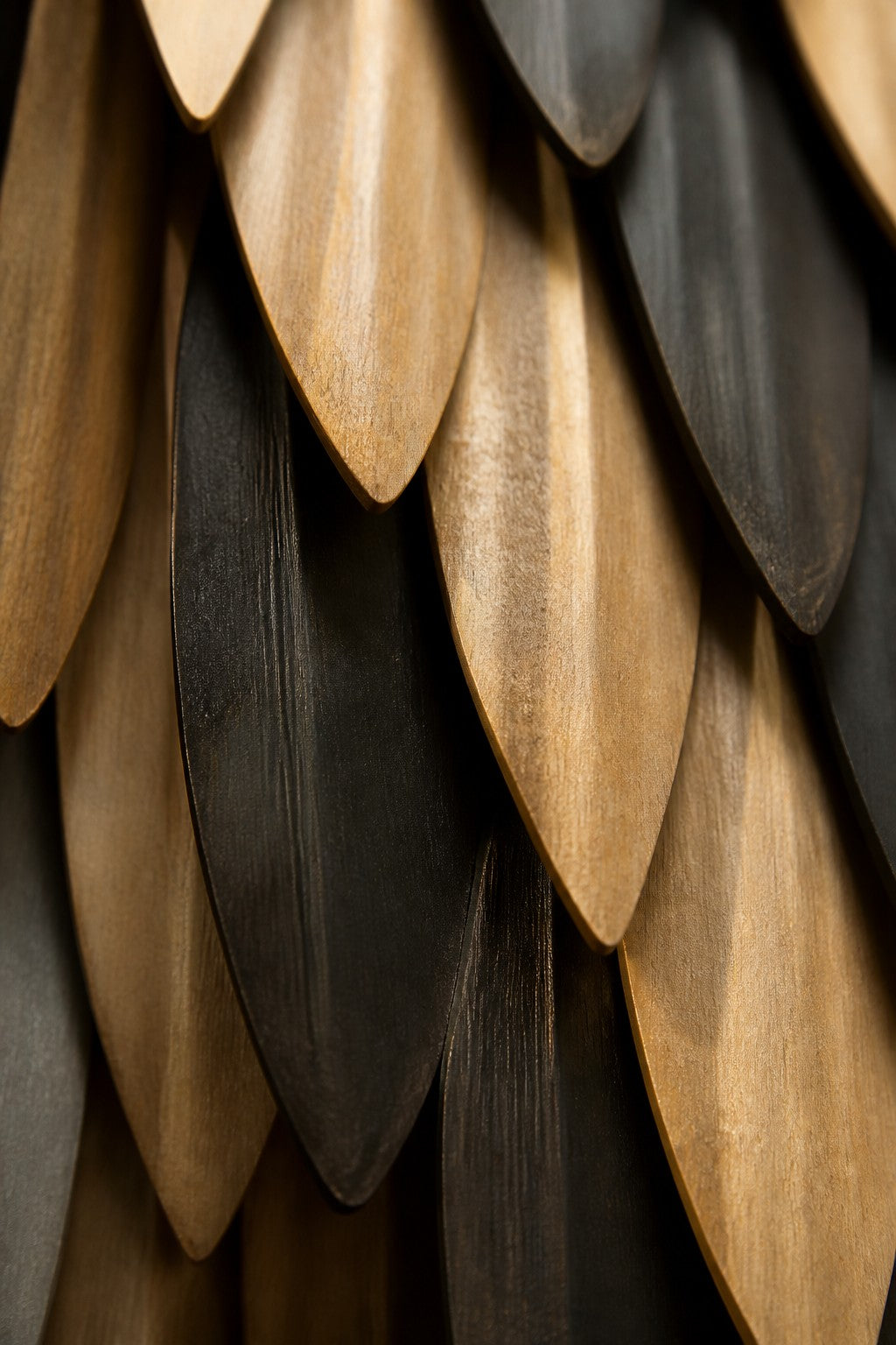 Sunbula — 80 × 150 cm tall oval wall sculpture of black and gold zig-zag plates, close studio detail of the surface and material