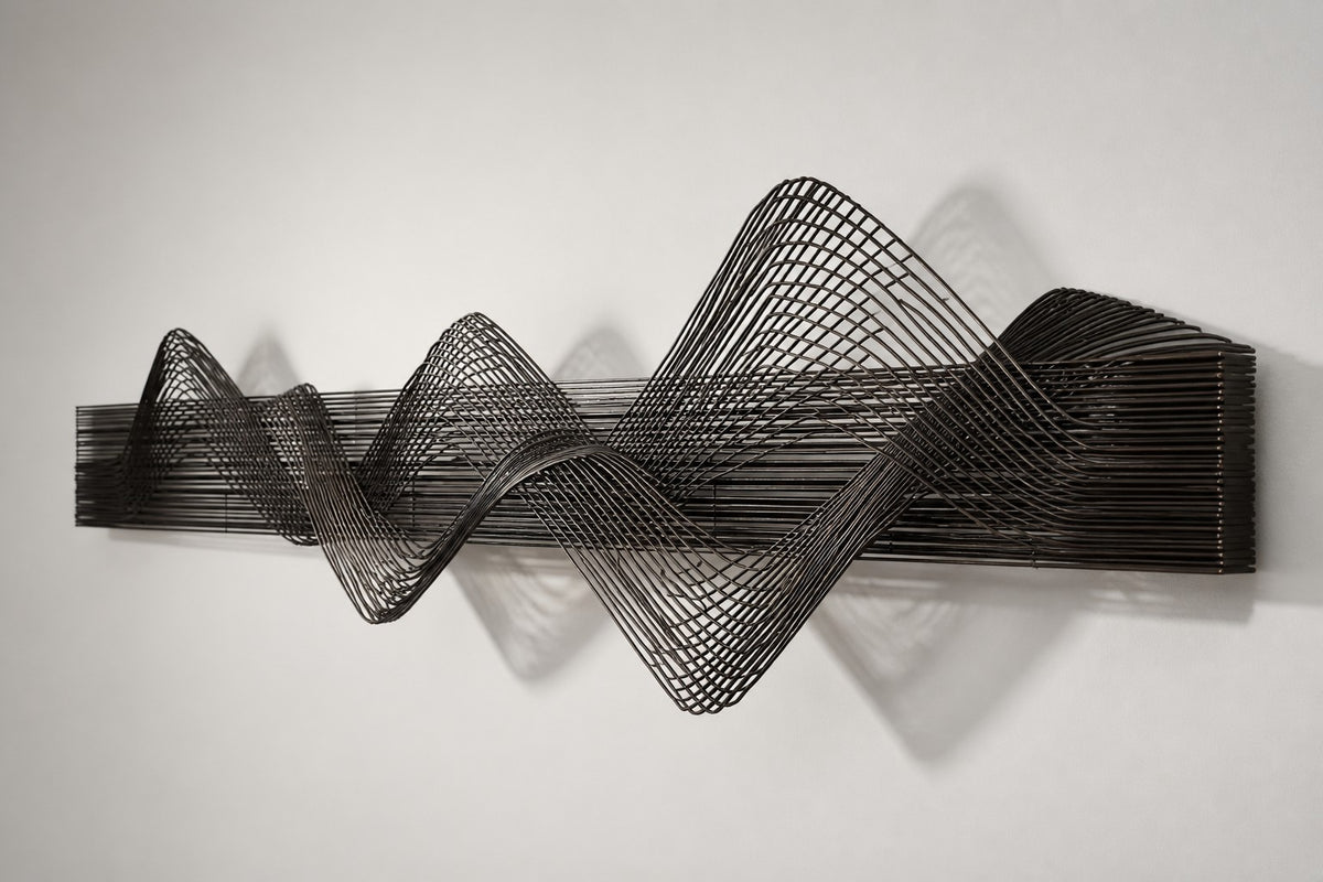 Susurro — dark bronze wire wave wall sculpture, studio side angle showing its depth