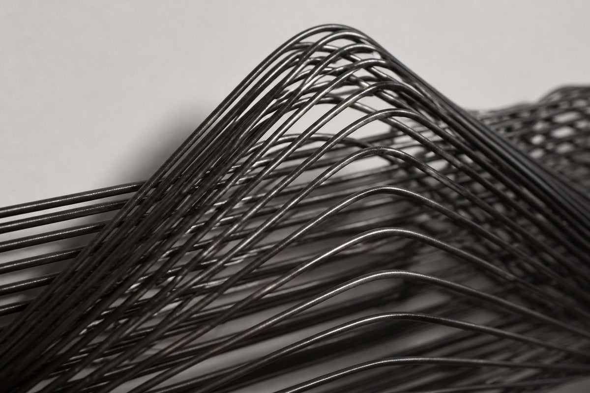 Susurro — dark bronze wire wave wall sculpture, close detail of the surface and edge