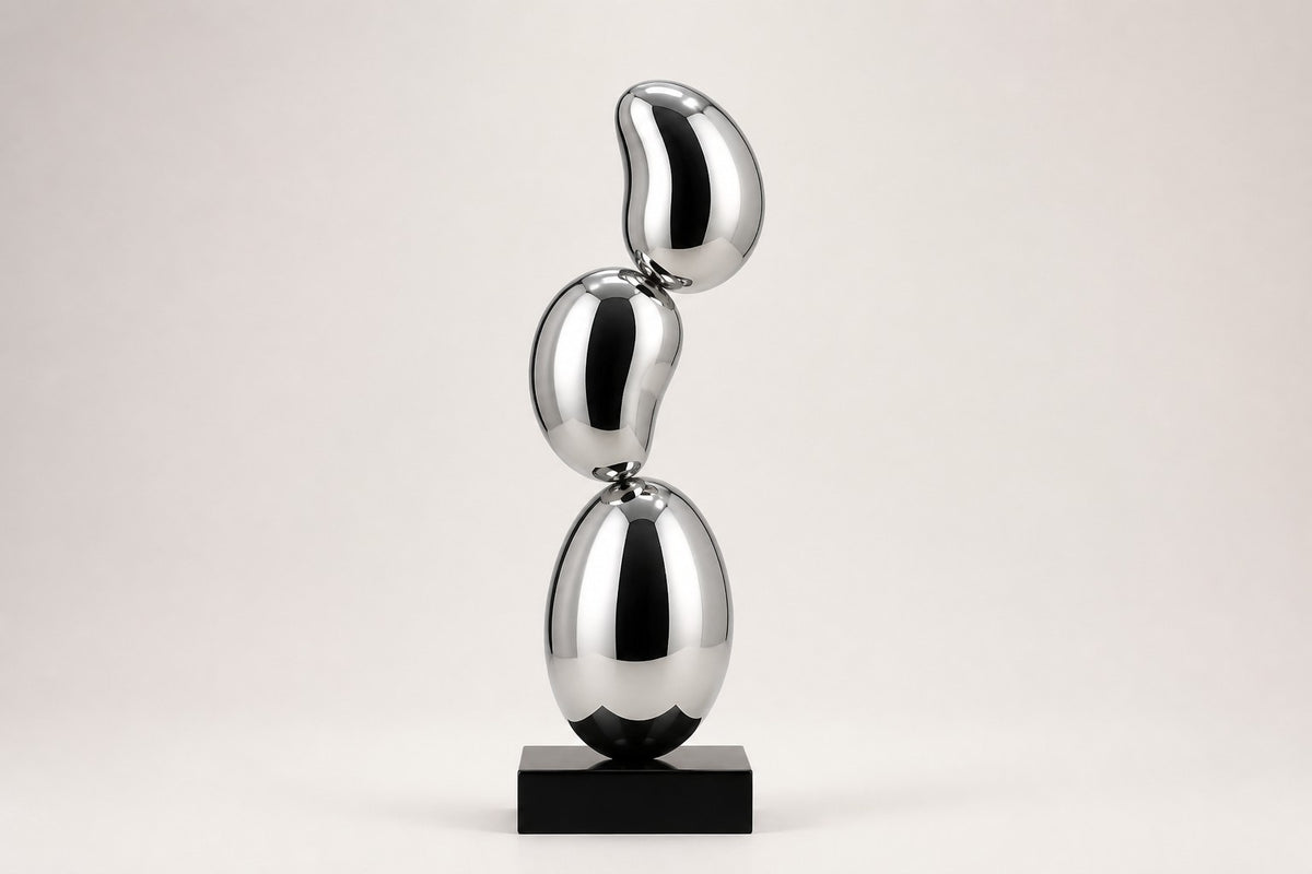 Tamago — mirror chrome stacked ovoid sculpture on a black base, studio front view