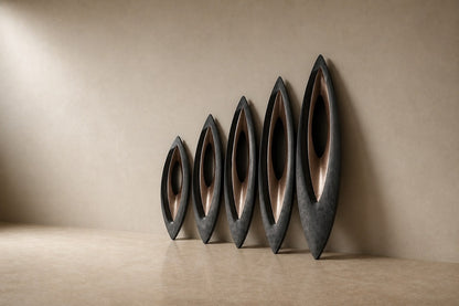 Five graduated lens-shaped bronze forms in ascending order, leaning against a plaster wall.