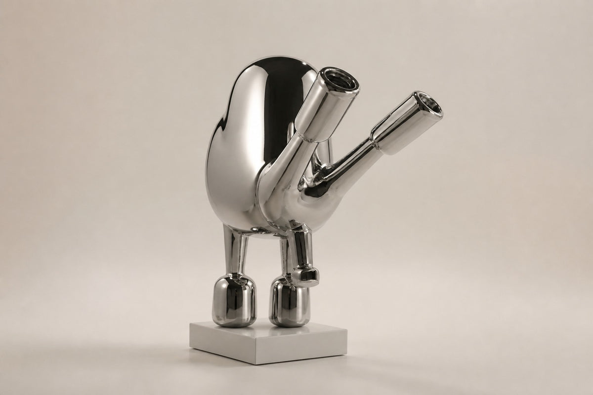 Tayr — 50 cm mirror-polished chrome balloon-form bird sculpture on a white base, three-quarter studio view showing its profile