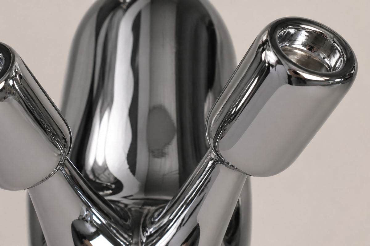 Tayr — 50 cm mirror-polished chrome balloon-form bird sculpture on a white base, close studio detail of the surface and material