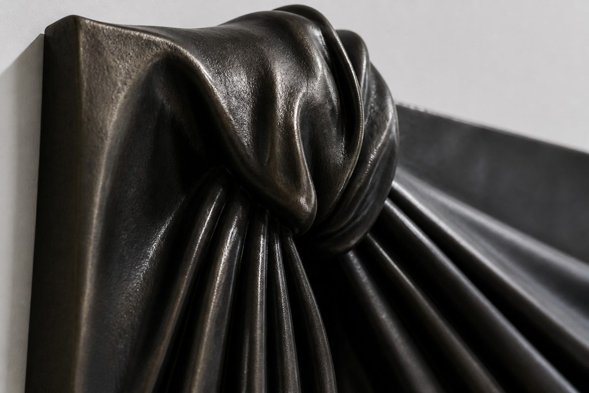 Telón — black bronze wall sculpture of theatre drapery in two deep swags, close detail of the surface and edge