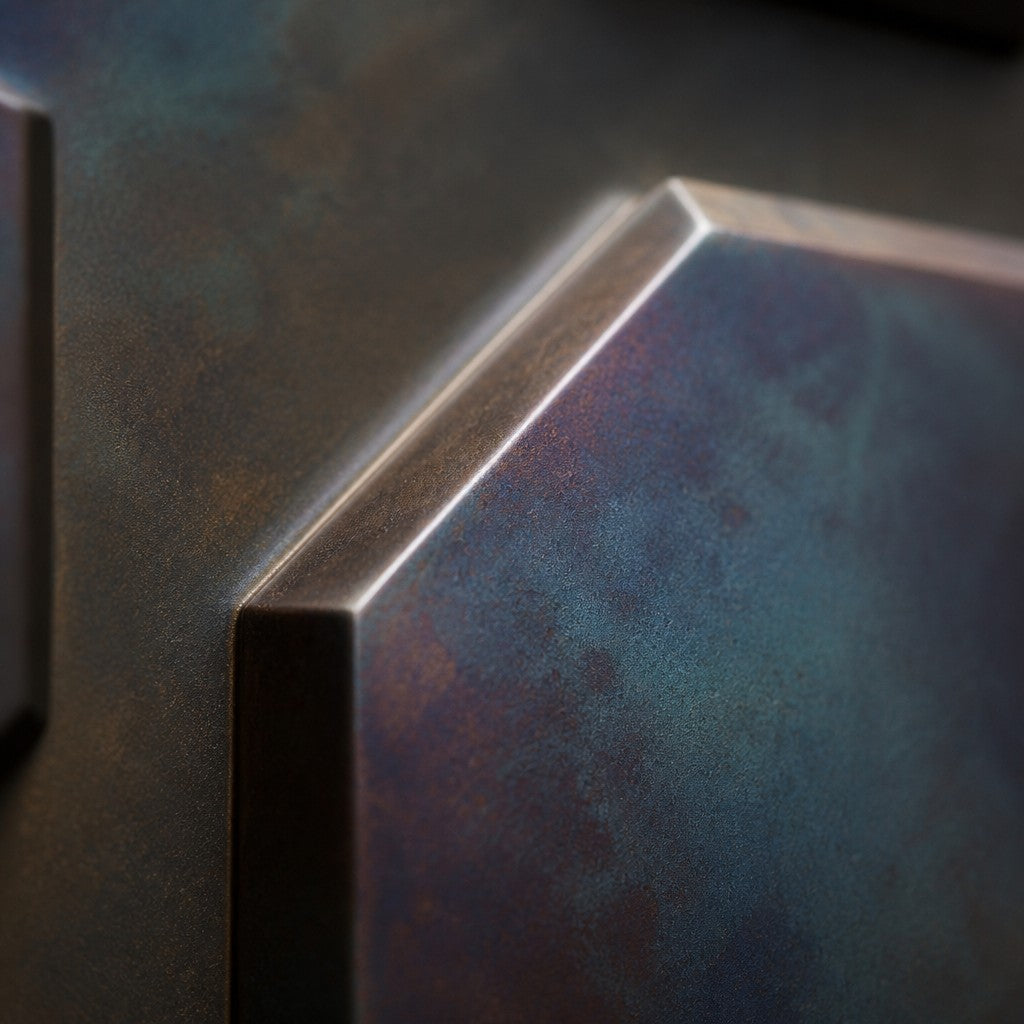 Tessera — 110 × 110 cm dark bronze wall panel of sixteen iridescent tiles in a grid, close studio detail of the surface and material