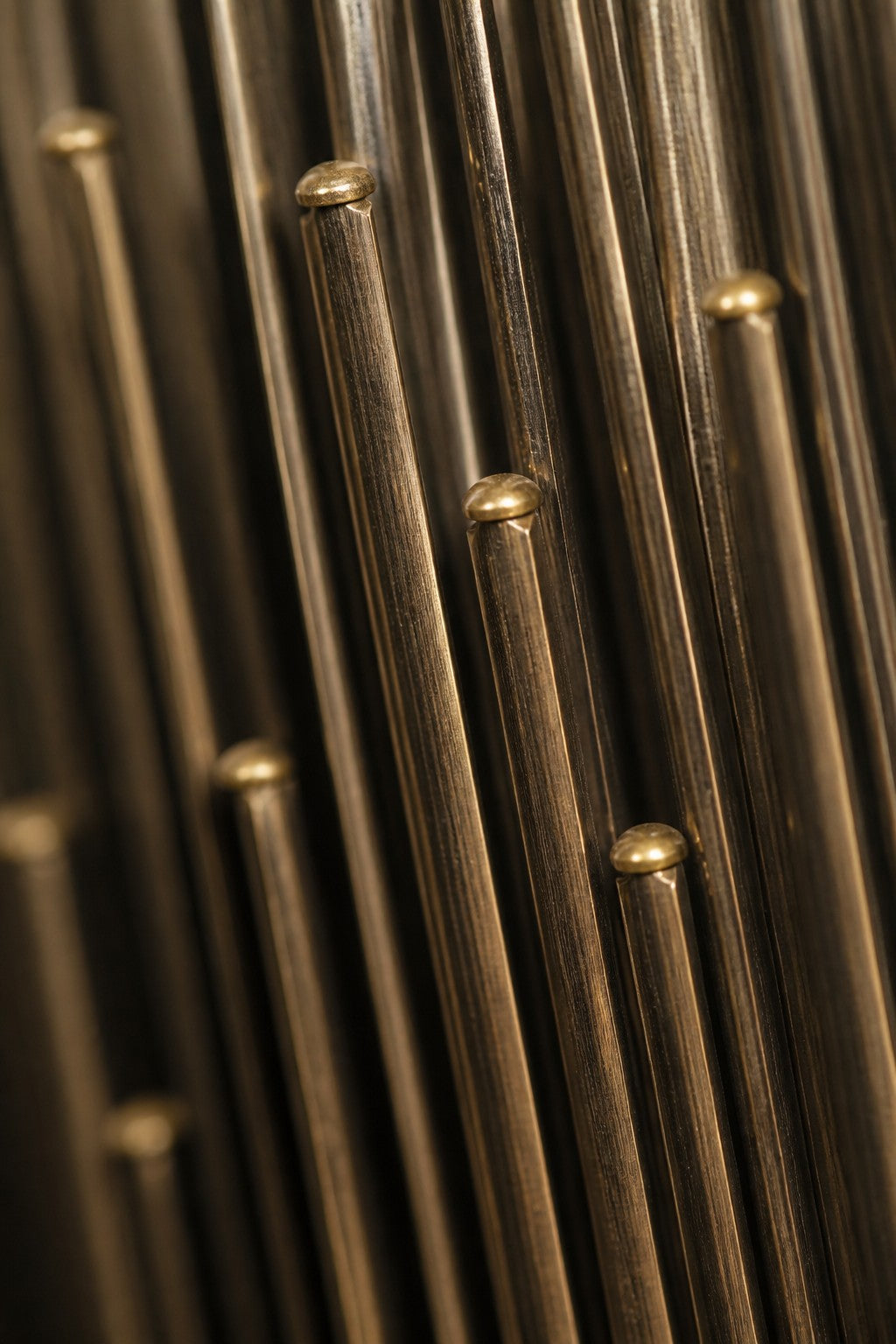 Tratto — 60 × 180 cm vertical cluster of blackened rods with polished brass nodes, close studio detail of the surface and material