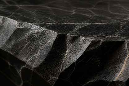 Black basalt fire table Tsukage 220, dense black with fine grey veining, on a pale stone floor.