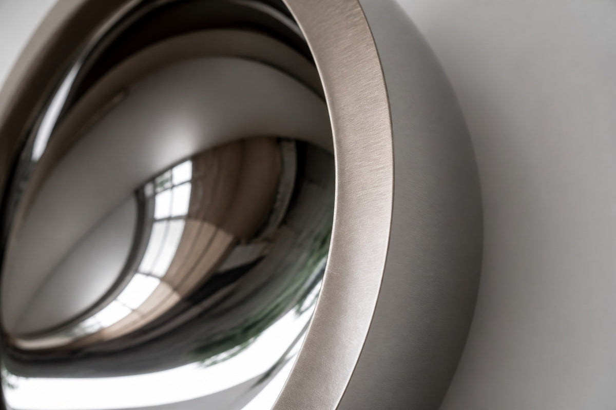 Tsuki — Ø 160 cm concave mirror stainless steel moon wall sculpture, close detail of the surface and edge