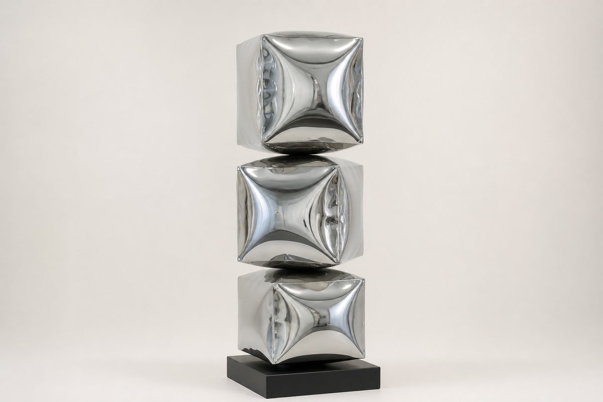 Tsumiki — 90 cm three stacked mirror-chrome inflated cubes on a black base, studio view of the whole piece