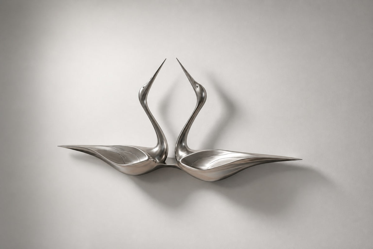 Tsuru — satin stainless steel pair of cranes wall sculpture, studio side angle showing its depth