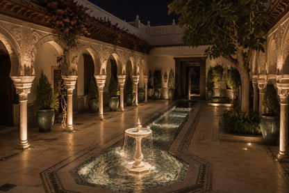 Pale limestone pedestal fountain Vasca Ø65, cream and white with amber veining, on a pale stone floor.