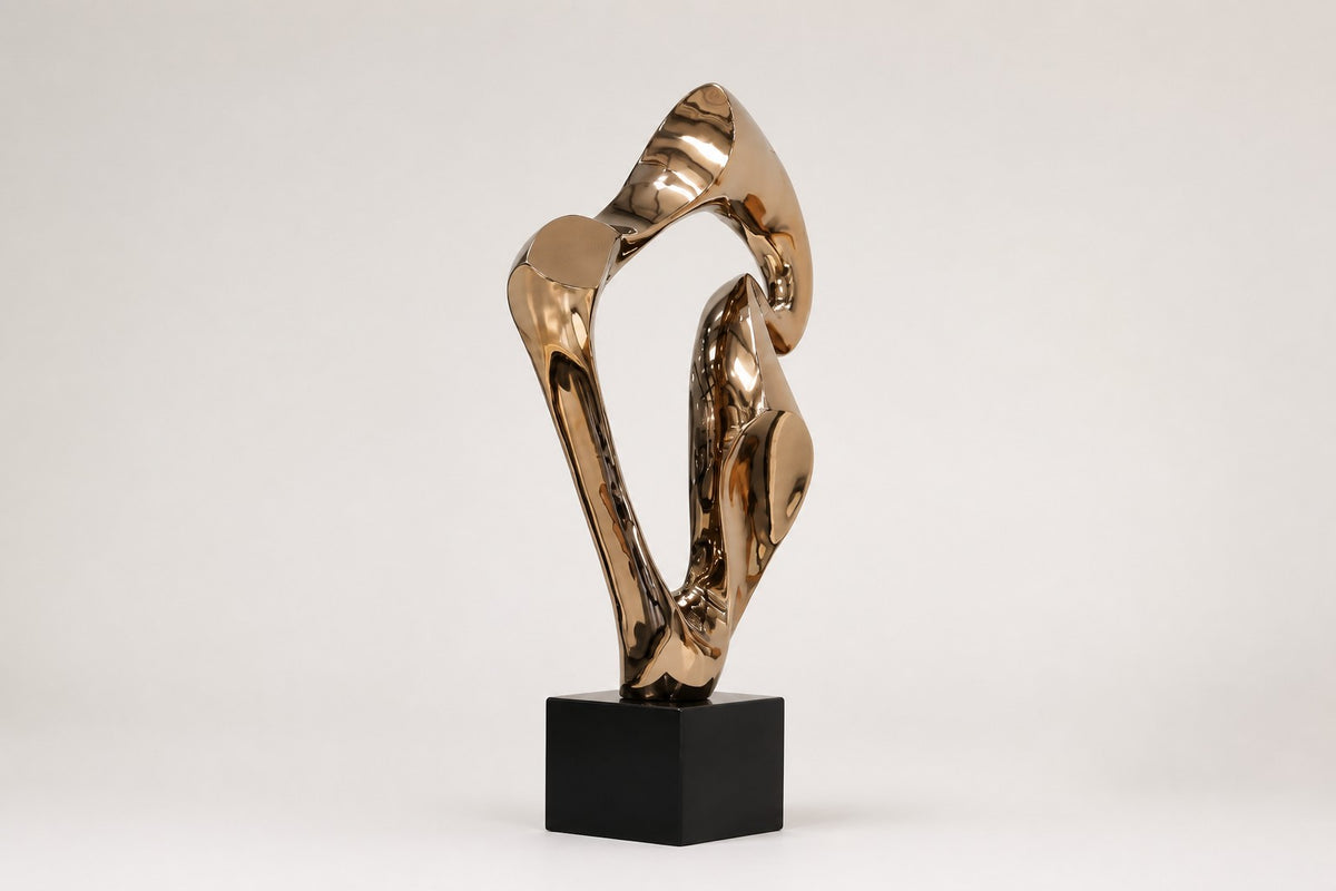 Vega — polished rose bronze abstract wing sculpture on a black base, studio front view