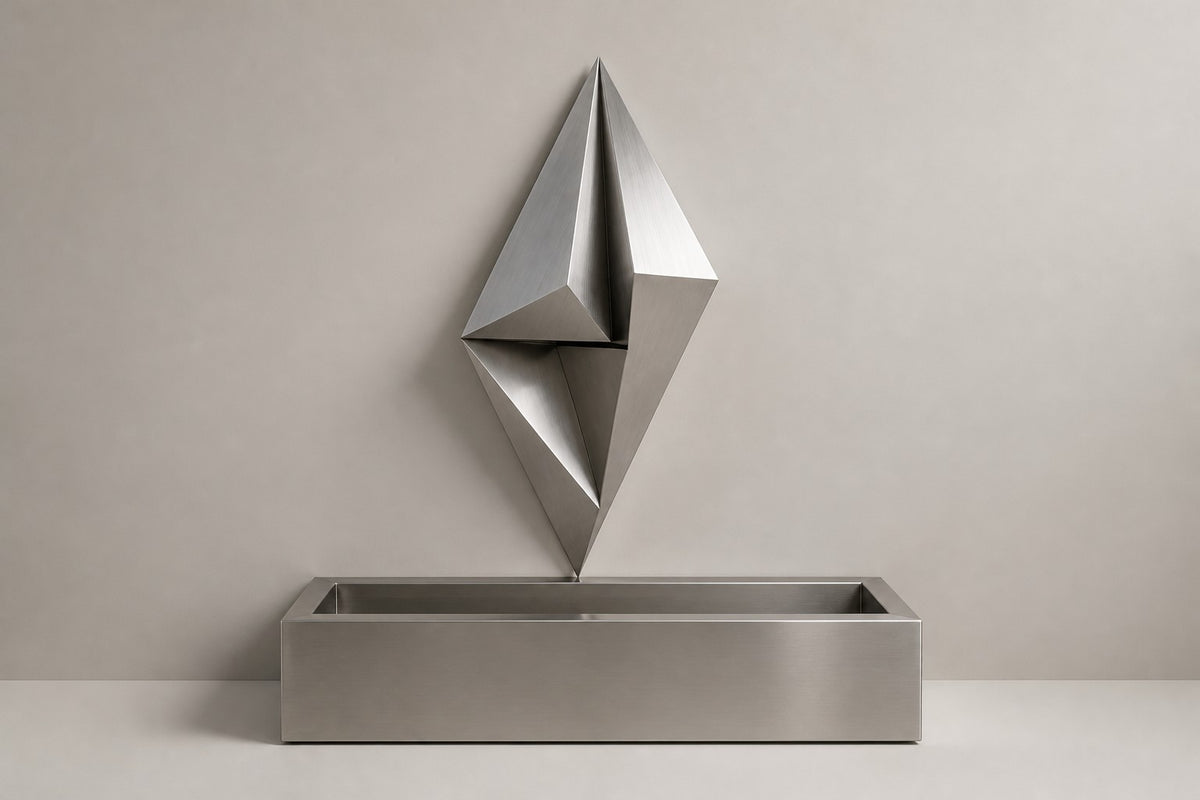 Veila — faceted stainless wall fountain, studio front view