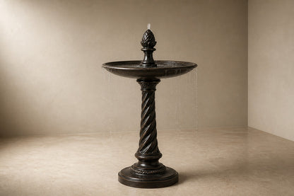 Stone pedestal fountain Wayrana Ø65, dark bronze, on a pale stone floor.