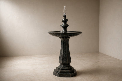 Stone pedestal fountain Yakura Ø65, dark green-black, on a pale stone floor.