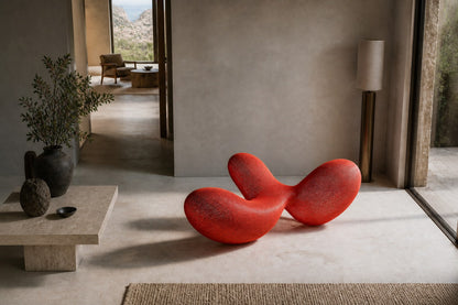 Coral red woven wire sculpture Zaurak, two full lobes drawn together through a narrow twist at the centre.